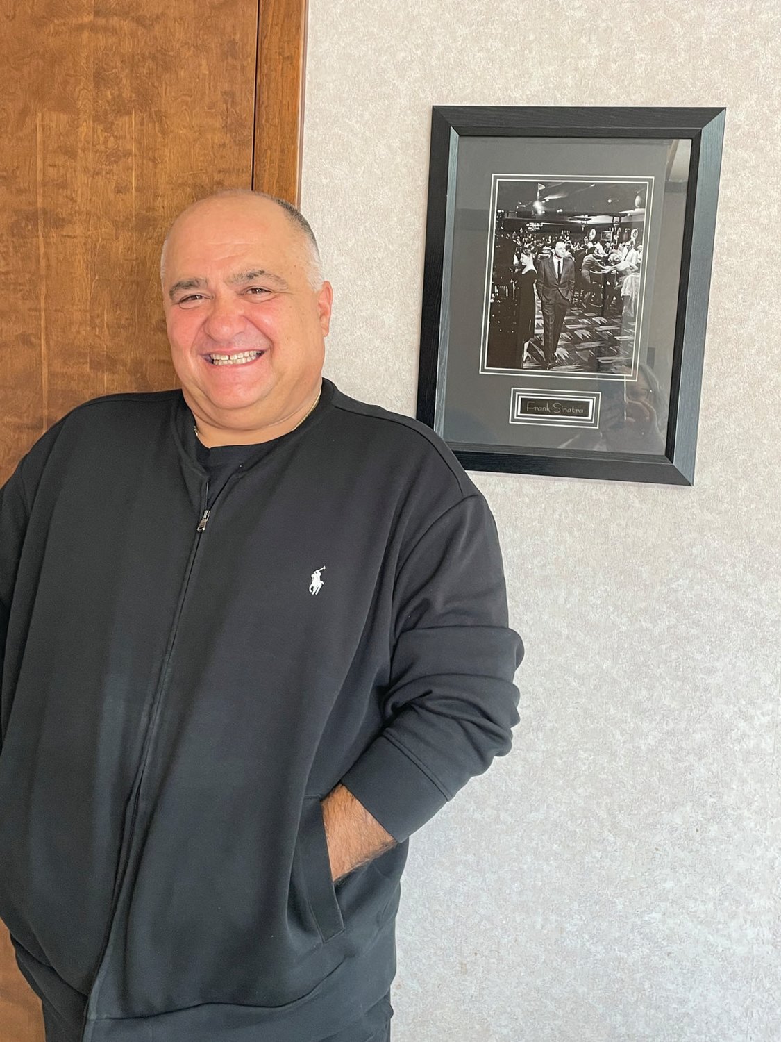 HALL OF FAMER:Terry McEnaney, also known as Bobby Braciolam poses with his icon, Frank Sinatra, at his law office in Cranston.